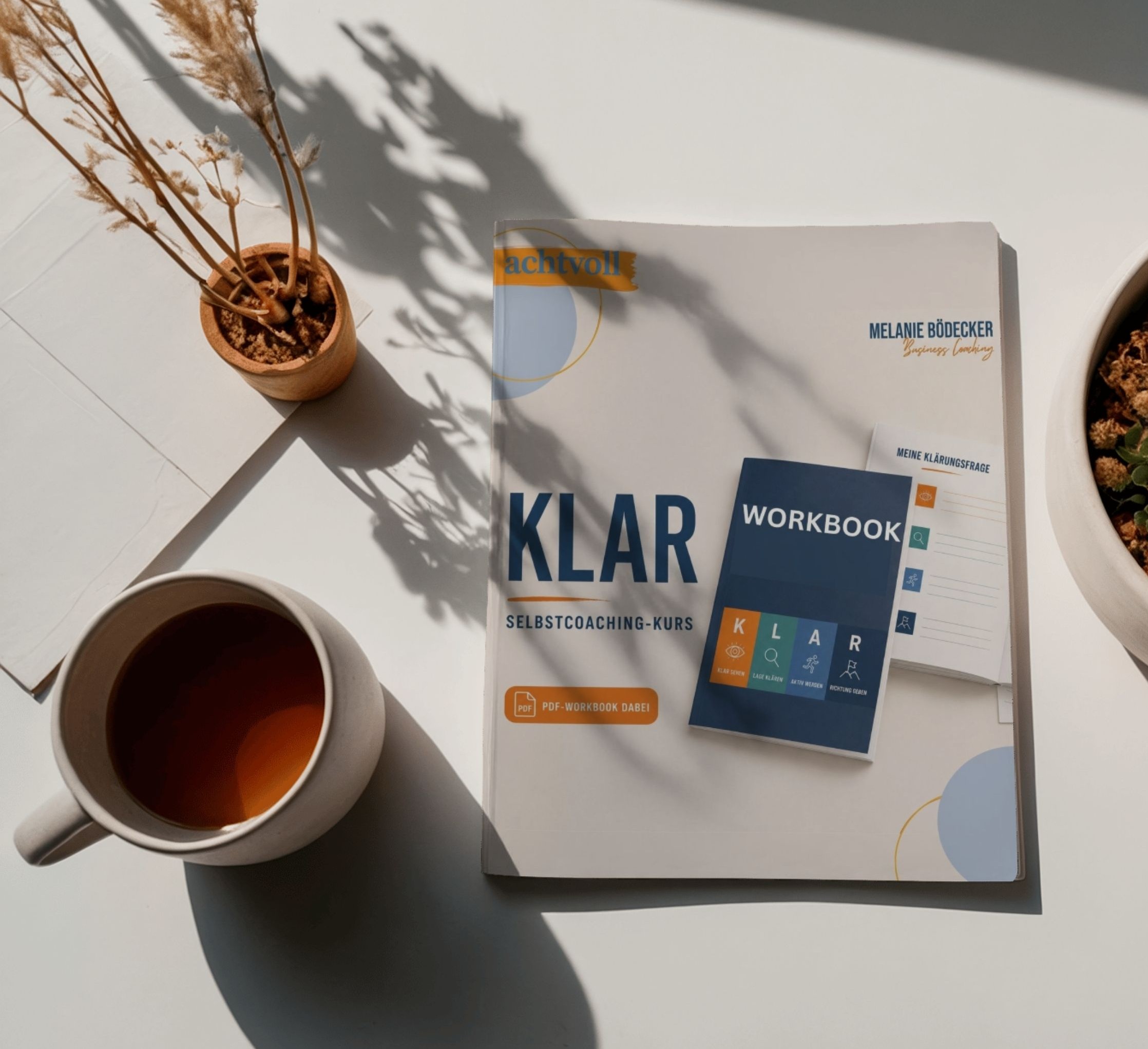 Das KLAR-Workbook liegt auf einem hellen Tisch neben einer Tasse Tee – Cover mit den vier Schritten Klar sehen, Lage klären, Aktiv werden, Richtung geben
